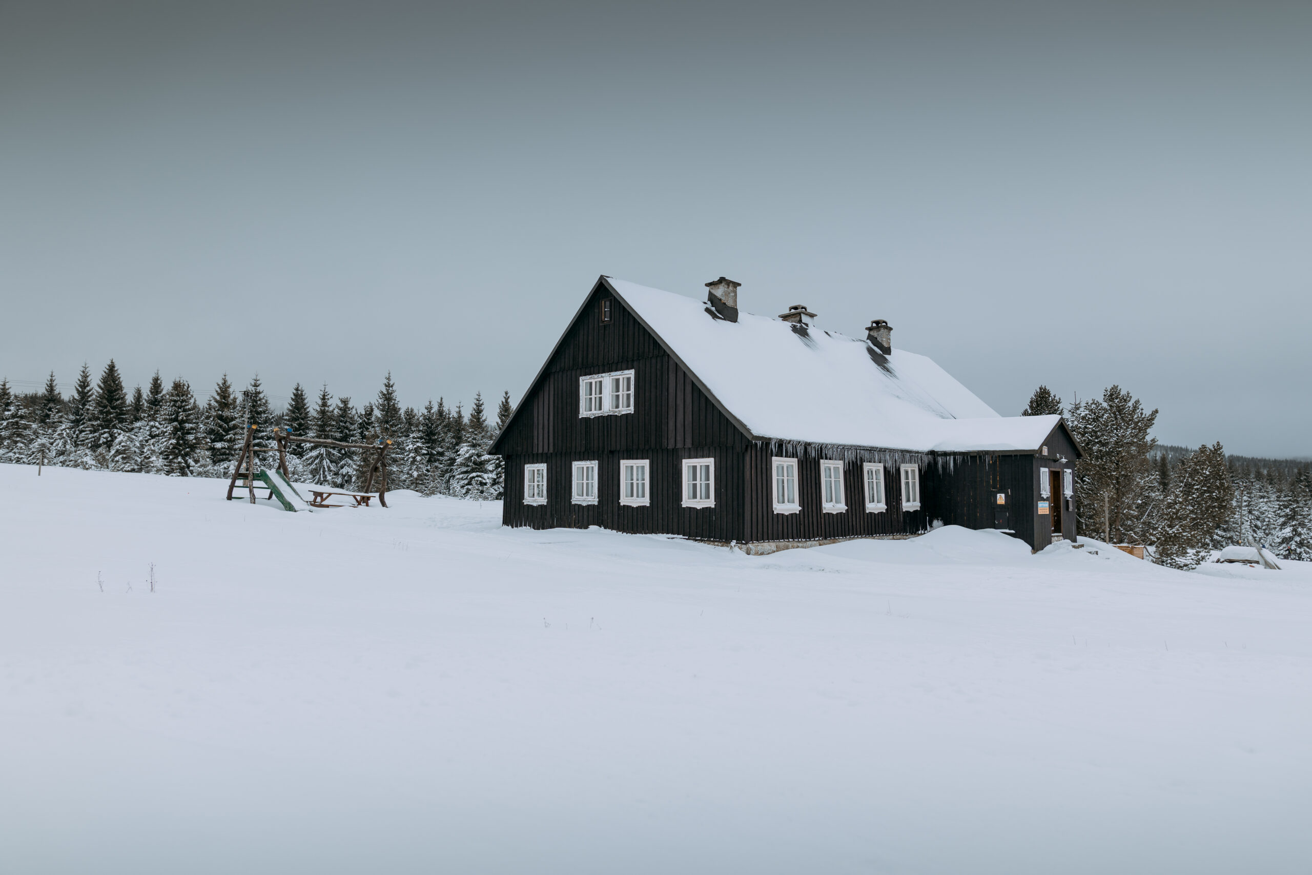 Landscape of a wooden house covered with snow